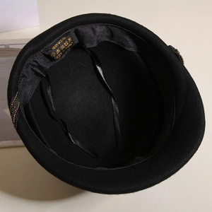 Detail view of 100% wool beret interior featuring ribbed sweatband and adjustment strap