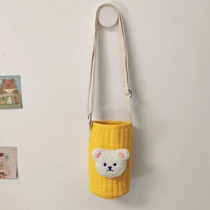 Detail of a quilted yellow water bottle bag featuring a 3D plush bear head with strap