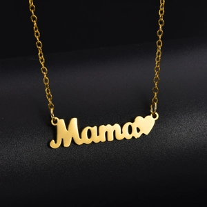 Dettaglio macro della collana dorata Mama con ciondolo a lettere e piccolo cuore