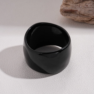 Close-up of a wide black resin geometric ring with a high-gloss polished finish