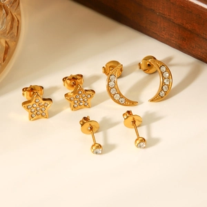 Detail of star, moon, and ball gold stud earrings set with sparkling rhinestones