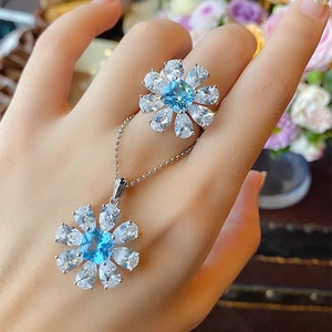 Blue sky topaz style flower jewelry set with silver necklace and ring on a model