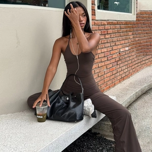 Photo en extérieur d'un mannequin portant une combinaison dos nu marron foncé à licou