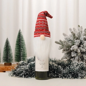 Détail du cache-bouteille de vin gnome en tricot rouge et blanc à motifs flocons