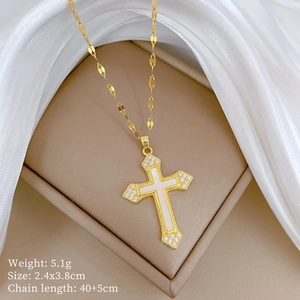 Detailed view of a gold cross necklace with white inlay and sparkling small diamonds