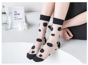 Close-up of sheer black tulle socks with polka dot pattern and solid heel detail