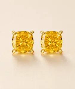 Primer plano de pendientes de diamantes amarillos de corte cojín con engaste de oro