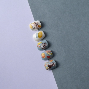 Macro shot of 5D embossed nail stickers featuring raccoon and pumpkin forest designs