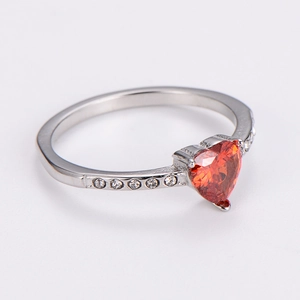 Detail view showing three-prong heart-shaped red zircon set on a silver stainless steel ring
