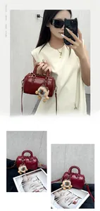 Detail of dark red Boston bag with smooth faux leather and cute sheep bag charm