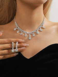 Close-up of sparkling rhinestone necklace and drop earrings on model for a luxury look