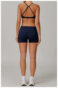 Detail showing cross-back design of navy blue sports bra and high-waist fitness shorts