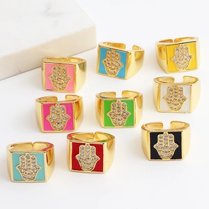 Macro detail of Hamsa Hand enamel rings with cubic zirconia inlay and gold plating