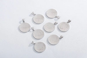 Detailed view of silver stainless steel round coin pendants with engraved mystic symbols