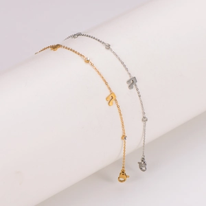 Chic gold and silver musical note anklets with crystal charms on white display