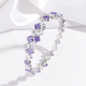 Close-up of alternating purple and white zircon crystals on a silver stainless steel cuff