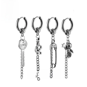 Detail of four punk style stainless steel earrings featuring key snake and astronaut charms