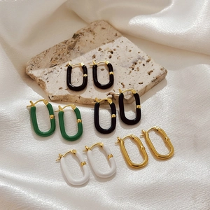 U-shaped stainless steel earrings in gold with black, white, and green enamel finishes