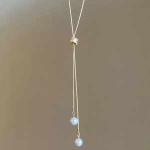 Détail du collier Y ajustable en chaîne serpent dorée avec curseur zircon et perles bleues