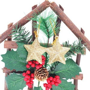 Wooden house frame ornament with gold glitter stars, pine cones, and red berries