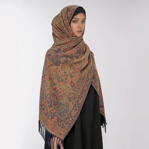 Close-up of paisley floral pattern and blue fringe tassels on a thick winter shawl