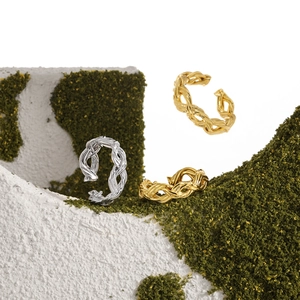 Elegant woven twist knot rings in gold and silver finish on a natural stone base