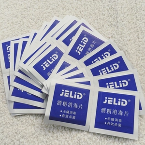 Multiple blue medical alcohol prep pads for earring and skin sterilization on white rug