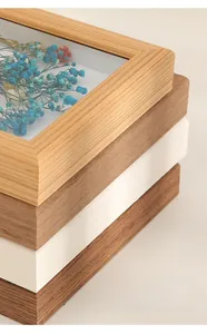 Close-up of stacked wooden frames showing natural wood grain and dried flower art