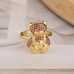 Macro detail of 18K gold plated bear ring featuring micro-paved pink and red zircons