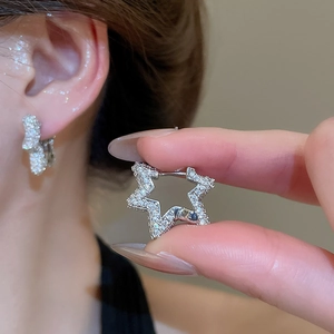 Detailed close-up of sparkling star-shaped silver hoop earrings with pave zircon settings