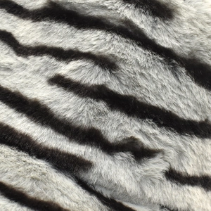 Detail der Textur von dickem Zebra-Kunstkaninchenfell auf warmem Herbst-Winter-Anglerhut