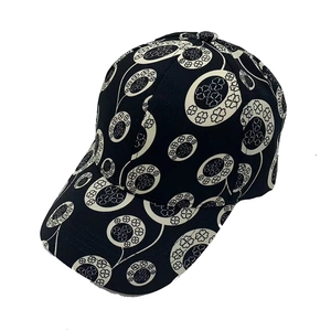 Close-up of baseball cap featuring black and white clover pattern and curved brim