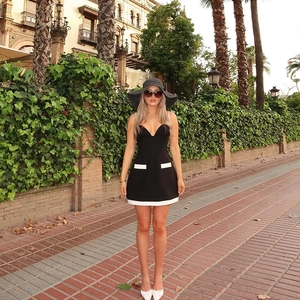 Detalle de minivestido negro con bolsillos y dobladillo blancos en contraste en modelo