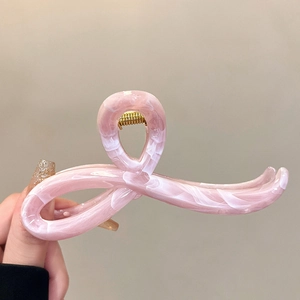 Detail of pink marble textured acetate hair claw clip with golden metal spring