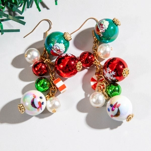 Detail of handmade Christmas beaded earrings with Santa Claus, snowmen and festive charms