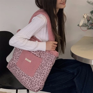 Close-up of pink leopard print tote bag with plush pocket detail worn by a model
