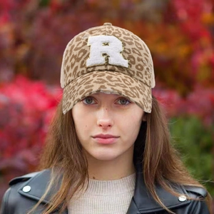 Detail view of leopard print ponytail hat with white towel embroidered R patch and distressed brim
