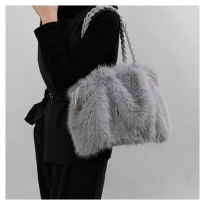 Detailed view of the gray faux fur tote bag with a woven strap held by a model