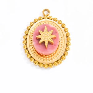 Vintage gold oval pendant with pink agate stone and embossed gold starburst detail
