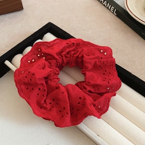 Detailed close-up of red lace hollow embroidery scrunchie with layered ruffle design
