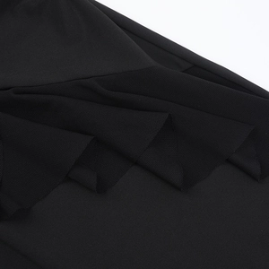 Detailed close-up of the black halter dress featuring mesh patchwork and elastic fabric texture