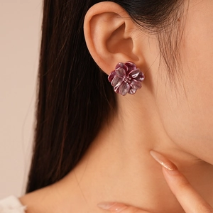 Boucles d'oreilles fleurs en résine violet mat vintage pour femme portées par un mannequin