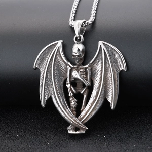 Macro shot of Gothic skull pendant with wings in vintage silver metal and dark texture