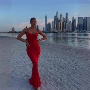 Close-up of red satin backless long dress with spaghetti straps at sunset