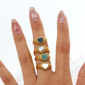 Detailed view of 18K gold plated braided rings with colorful heart-shaped stones