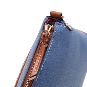Close-up of blue lychee grain leather handbag with brown braided leather zipper pull detail
