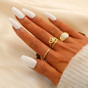 Set of three elegant gold titanium steel rings with heart design on hand model