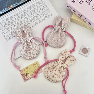 Close-up of floral drawstring storage pouches with rabbit ears in three pastel colors