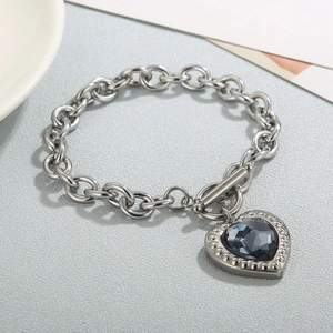 Detail of OT buckle closure and silver heart charm bracelet with faceted dark gemstone