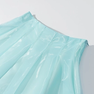 Détail de la mini-jupe en satin bleu clair avec plis à la taille et fermeture éclair invisible